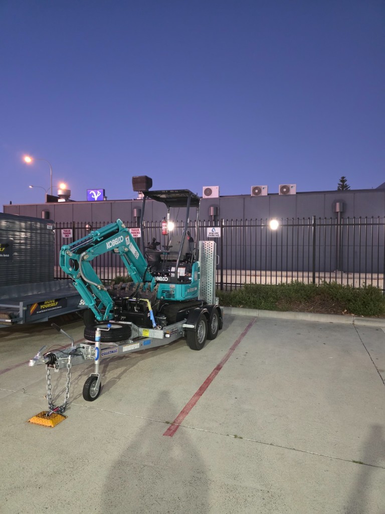 Kobelco SK17SR-6 mini excavator on plant trailer ready for pickup at BP Port Kennedy